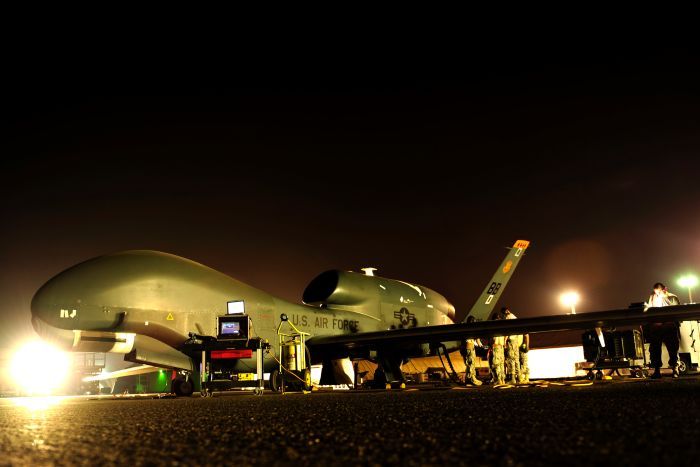 A Global Hawk spy drone is prepared for a night mission at an undisclosed location in the Middle East.